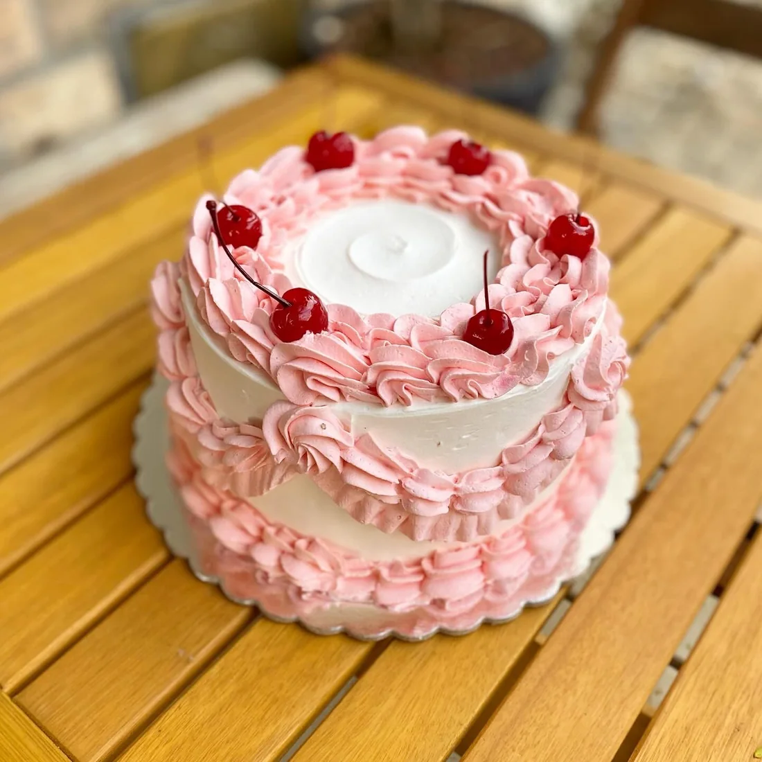 Bolo rosa com frutas e acabamento clássico